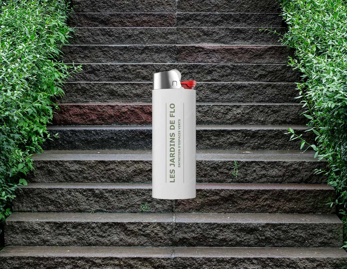Briquet blanc personnalisé avec le logo vertical Les Jardins de Flo posé sur des marches en pierre.