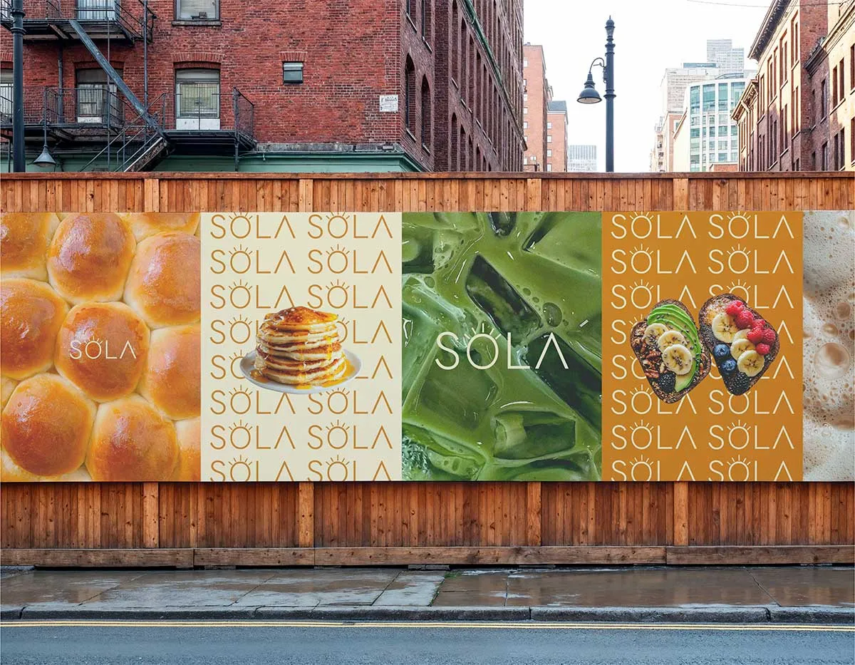 Série d'affiches publicitaires SOLA collées sur une palissade en bois dans la rue, présentant des visuels de brioches, pancakes, matcha et avocado toasts.